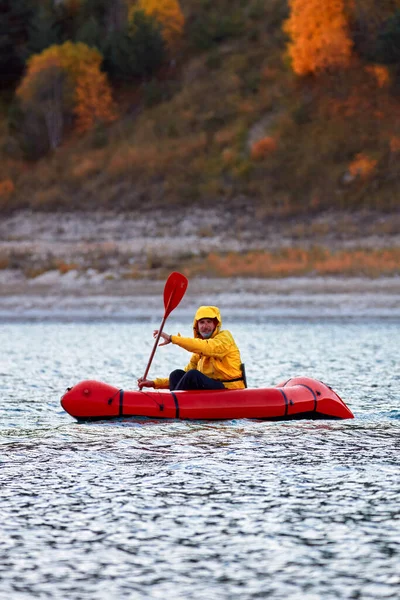 Packraft, zattera leggera da una persona utilizzata per la spedizione o l'avventura su un lago, barca gonfiabile Cavalcare su un lago di montagna — Foto Stock