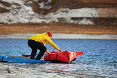Paketleme gemisiyle açılmak. Packraft (keşif veya macera yarışı için kullanılan tek kişilik hafif sal) bir gölde, şişme bir teknede dağ gölünde gezinti.