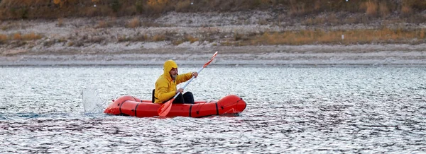 Nada en Packraft. Packraft, balsa ligera de una persona usada para la expedición o las carreras de la aventura, en un lago, paseo inflable del barco en un lago de montaña —  Fotos de Stock