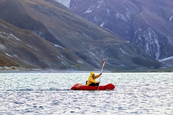 Schwimmen im Packfloß. Packraft, leichtes Ein-Personen-Floß für Expeditionen oder Abenteuer-Rennen auf einem See, Schlauchbootfahrt auf einem Bergsee — Stockfoto