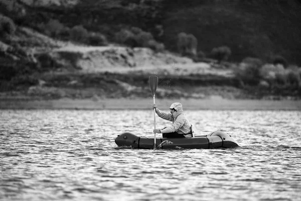 Schwimmen im Packfloß. Packraft, leichtes Ein-Personen-Floß für Expeditionen oder Abenteuer-Rennen auf einem See, Schlauchbootfahrt auf einem Bergsee — Stockfoto