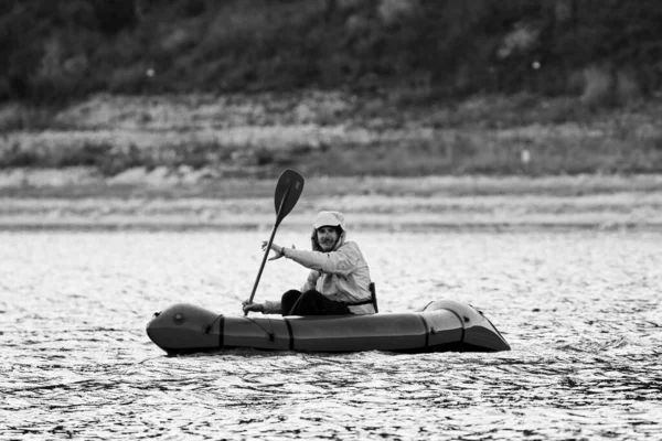 パックラフトで泳ぐ。探検やアドベンチャーレースに使用されるパックラフト、 1人の軽量ラフト、湖、膨脹可能なボートに乗って山の湖に乗る — ストック写真