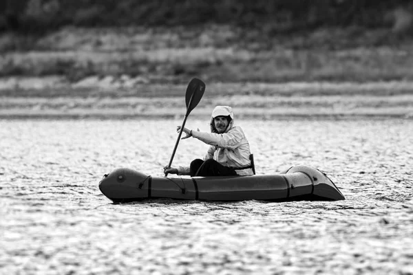 패킷 뗏목으로 수영 한다. 픽업 (Packraft), 원정대나 모험 경주를 위해 사용되는 1 인승가벼운 뗏목, 호수 위에서 부풀어 오르는 보트타기 — 스톡 사진