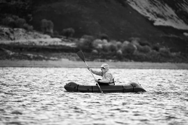 패킷 뗏목으로 수영 한다. 픽업 (Packraft), 원정대나 모험 경주를 위해 사용되는 1 인승가벼운 뗏목, 호수 위에서 부풀어 오르는 보트타기 — 스톡 사진