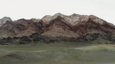 Moğolistan 'daki dağların havadan görünüşü. Vadide bozkır ve güzel renkli dağlar. 4k, 10 bit..