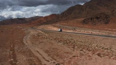 Araba yola çıkıyor. Dağlarda güzel asfalt yollar var. Yeni otoyol. Vahşi doğadaki dağ manzarası. Çölde yol gezisi.