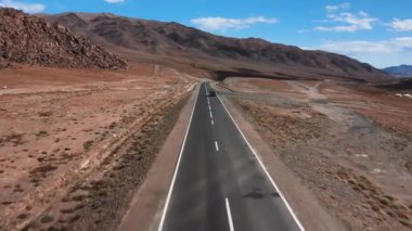 Araba yola çıkıyor. Dağlarda güzel asfalt yollar var. Yeni otoyol. Vahşi doğadaki dağ manzarası. Çölde yol gezisi.