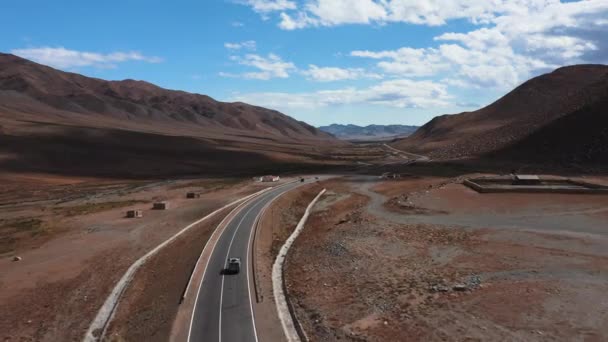 車は道路を進みます 山の中で美しい舗装道路 新しい高速道路だ 野生の山の風景です 砂漠を巡るロードトリップ — ストック動画