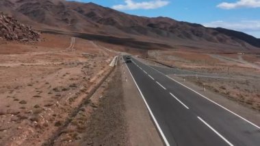 Araba yola çıkıyor. Dağlarda güzel asfalt yollar var. Yeni otoyol. Vahşi doğadaki dağ manzarası. Çölde yol gezisi.