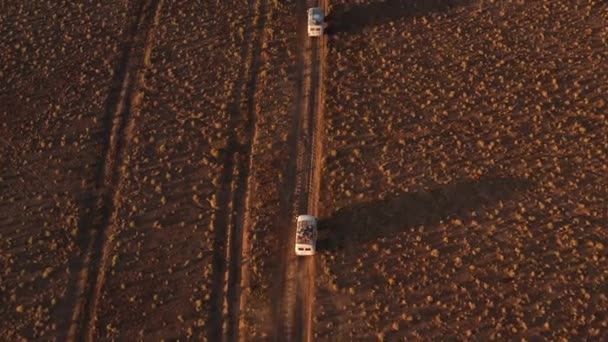 Légi felvétel a 4x4-es útról, földúton haladva a sivatagban. Gyönyörű vad út a sivatagban naplementekor. Kirándulás egy sivatagi Aerial View — Stock videók