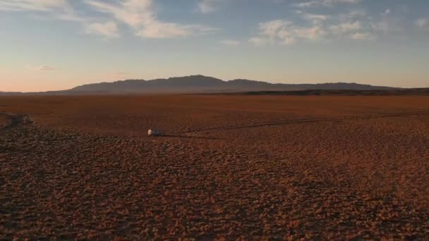 Vista aérea off road 4x4 carro dirigindo ao longo da estrada de terra entre o deserto. Bela estrada selvagem no deserto ao pôr-do-sol. Viagem de carro através de uma vista aérea do deserto — Vídeo de Stock