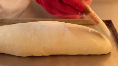 Mutfakta üretim süreci var. İştah açıcı bir hamurun oluşumu için hamur üzerine çırpılmış yumurta fırçalamak. Tepsi fırında pişirmeye hazır. Yavaş çekim 100 fps, derecelendirilmemiş video