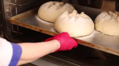 Fabrikadaki fırın işlemleri. Fırın faaliyeti. Pişmeden önce ekmek hamuru hazırlama işlemi. Fırında ekmek var. Fırında ağır çekimde çalışmak 100 fps. derecelendirilmemiş video