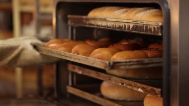 Fabrikadaki fırın işlemleri. Fırın faaliyeti. Pişmeden önce ekmek hamuru hazırlama işlemi. Fırında ekmek var. Fırında ağır çekimde çalışmak 100 fps. derecelendirilmemiş video