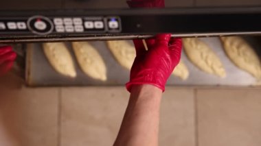 Fabrikadaki fırın işlemleri. Fırın faaliyeti. Pişmeden önce ekmek hamuru hazırlama işlemi. Fırında ekmek var. Fırında ağır çekimde çalışmak 100 fps. derecelendirilmemiş video