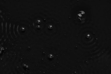 Sıvının yüzeyinde kabarcıklar var. Soyut Siyah Arkaplan Sıvı Doku