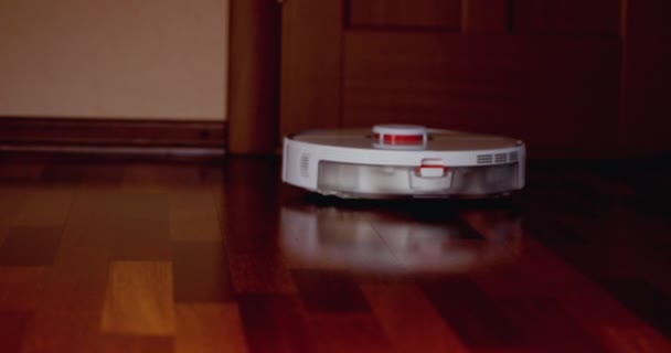 木製の床にライダー付きスマートロボット掃除機 ロボット掃除機はアパートの自動クリーニングを実行します 4Kスローモーション100 Fps Prores 422 10ビット — ストック動画