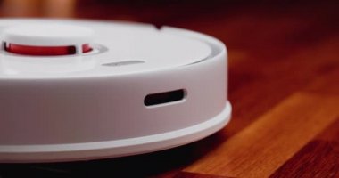 Ahşap zemininde karaciğer olan akıllı robot süpürgesi. Robot elektrikli süpürge daireyi otomatik olarak temizliyor. 4K ağır çekim 100 fps, ProRes 422, 10 bit.
