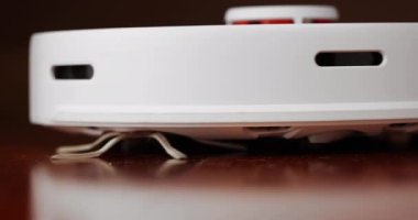 Ahşap zemininde karaciğer olan akıllı robot süpürgesi. Robot elektrikli süpürge daireyi otomatik olarak temizliyor. 4K ağır çekim 100 fps, ProRes 422, 10 bit