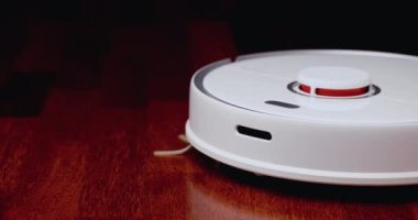 Ahşap zemininde karaciğer olan akıllı robot süpürgesi. Robot elektrikli süpürge daireyi otomatik olarak temizliyor. 4K ağır çekim 100 fps, ProRes 422, 10 bit