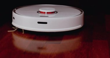 Ahşap zemininde karaciğer olan akıllı robot süpürgesi. Robot elektrikli süpürge daireyi otomatik olarak temizliyor. 4K ağır çekim 100 fps, ProRes 422, 10 bit