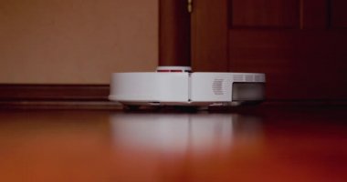 Ahşap zemininde karaciğer olan akıllı robot süpürgesi. Robot elektrikli süpürge daireyi otomatik olarak temizliyor. 4K ağır çekim 100 fps, ProRes 422, 10 bit