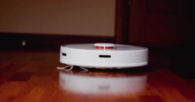 Ahşap zemininde karaciğer olan akıllı robot süpürgesi. Robot elektrikli süpürge daireyi otomatik olarak temizliyor. 4K ağır çekim 100 fps, ProRes 422, 10 bit