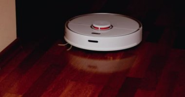 Ahşap zemininde karaciğer olan akıllı robot süpürgesi. Robot elektrikli süpürge daireyi otomatik olarak temizliyor. 4K ağır çekim 100 fps, ProRes 422, 10 bit