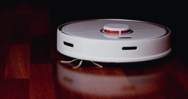 Ahşap zemininde karaciğer olan akıllı robot süpürgesi. Robot elektrikli süpürge daireyi otomatik olarak temizliyor. 4K ağır çekim 100 fps, ProRes 422, 10 bit