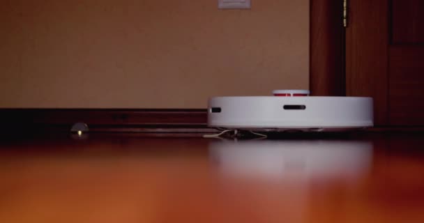 Robô inteligente Aspirador com lidar no chão de madeira. Aspirador robô realiza a limpeza automática do apartamento. 4K câmera lenta 100 fps, ProRes 422, 10 bits — Vídeo de Stock