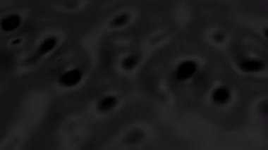 Splashes and drops on the surface of the liquid. Abstract Black Background Water vibration. 4K slow motion 100 fps, ProRes 422, 10 bit