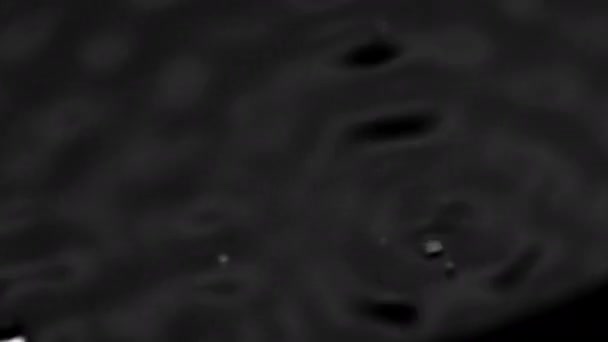 Всплески и капли на поверхность жидкости. Абстрактная вибрация чернозема. 4K slow motion 100 fps, ProRes 422, 10 bit — стоковое видео