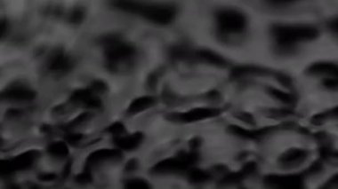 Splashes and drops on the surface of the liquid. Abstract Black Background Water vibration. 4K slow motion 100 fps, ProRes 422, 10 bit