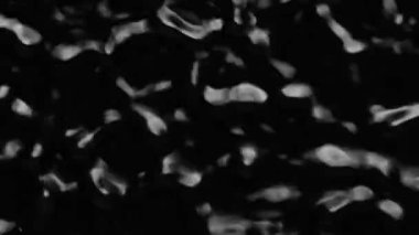 Splashes and drops on the surface of the liquid. Abstract Black Background Water vibration. 4K slow motion 100 fps, ProRes 422, 10 bit