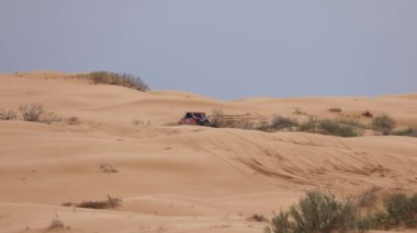 Off Road Extreme Racing 'in spor arabası kumda yapılan ralli baskını sırasında güzergahın zor kısmını aşıyor. KAGAN-2021 'in altını. Ağır çekim 120 fp. 25.04.2021 Astrakhan, Rusya