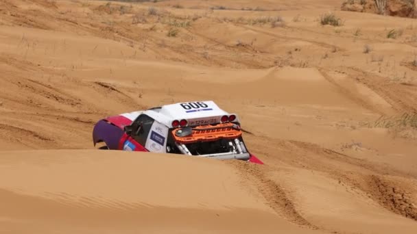 オフロード・エクストリーム・レーシングのためのスポーツカーは、砂のラリー・レード中にルートの困難な部分を乗り越える。KAGAN-2021の黄金。スローモーション120fps。25.04.2021ロシアのアストラハン — ストック動画
