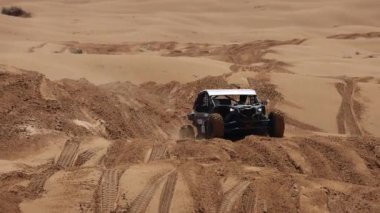 Off Road Extreme Racing 'in spor arabası kumda yapılan ralli baskını sırasında güzergahın zor kısmını aşıyor. KAGAN-2021 'in altını. Ağır çekim 120 fp. 25.04.2021 Astrakhan, Rusya