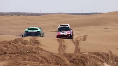 Off Road Extreme Racing 'in spor arabası kumda yapılan ralli baskını sırasında güzergahın zor kısmını aşıyor. KAGAN-2021 'in altını. Ağır çekim 120 fp. 25.04.2021 Astrakhan, Rusya