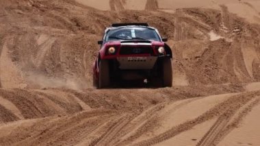Off Road Extreme Racing 'in spor arabası kumda yapılan ralli baskını sırasında güzergahın zor kısmını aşıyor. KAGAN-2021 'in altını. Ağır çekim 120 fp. 25.04.2021 Astrakhan, Rusya