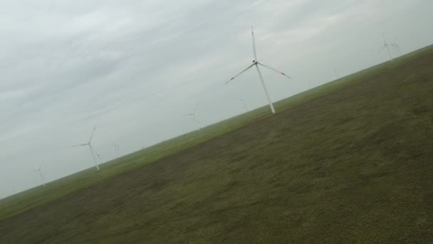 エネルギー生産のための強力な風力タービンファームの空中ビュー。風力発電機は、持続可能な開発のためにクリーンな再生可能エネルギーを生み出す。代替エネルギーだ。4K — ストック動画