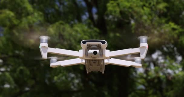 Un pequeño helicóptero blanco volando sobre el fondo de un árbol. cámara lenta 100 fps. vídeo Macro sin clasificar — Vídeos de Stock