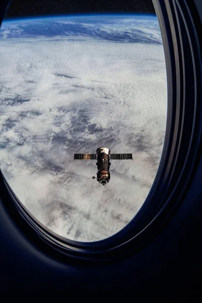 Ver en ISS Progreso reabastecimiento de la nave, Vista desde una ventana de pasajeros en el SpaceX Crew Dragon. Maniobra de acoplamiento cerca de la Estación Espacial. Elementos de imagen proporcionados por la NASA —  Fotos de Stock