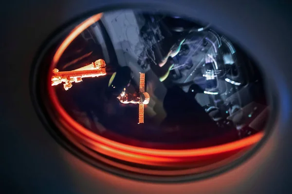 Lihat di ISS Progress memasok kapal, Lihat keluar dari jendela penumpang di SpaceX Crew Dragon. Mendarat manuver dekat Space Station. Elemen gambar dilengkapi oleh NASA — Stok Foto