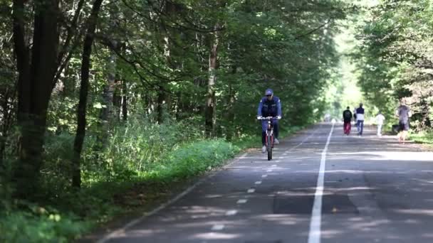 El anciano está en bicicleta en el parque, disfrutando del deporte o el hobby de vivir sano. Ciclismo en el parque, mantenerse en forma en la edad adulta. 4K cámara lenta 120 fps de vídeo. 28.08.2021, Región de Moscú — Vídeos de Stock