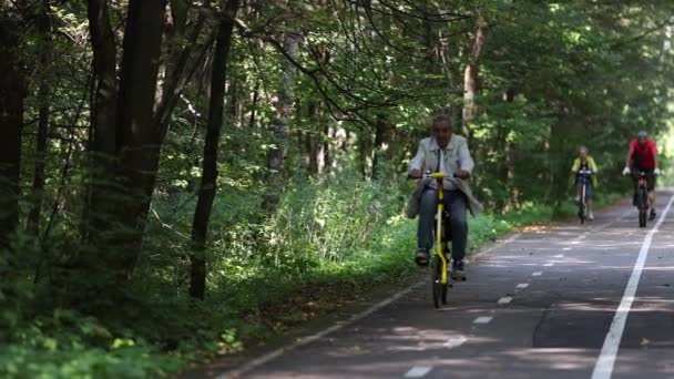 老人は公園で自転車をサイクリングしています-健康的なスポーツや趣味を楽しんでいます。公園でのサイクリング,大人にフィットを維持.4Kスローモーション120 fpsビデオ.28.8.2021,モスクワ地方 — ストック動画