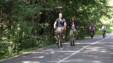 Yaşlı adam parkta bisiklet sürüyor - spordan ya da sağlıklı yaşamaktan zevk alıyor. Parkta bisiklet sürmek, yetişkinliğe ayak uydurmak. 4K ağır çekim 120 fps video. 28.08.2021, Moskova Bölgesi