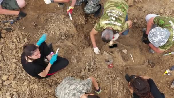 Escavações no local de um crime de guerra. Local de um tiroteio em massa de pessoas. Restos humanos ossos de esqueleto, crânios. Restos humanos de vítimas dos nazis. 28.08.2021, região de Rostov, Rússia — Vídeo de Stock