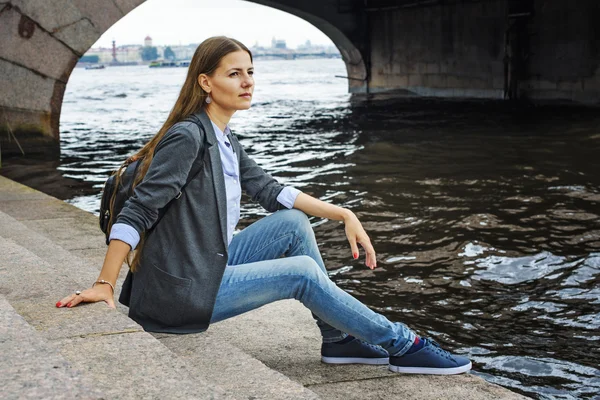 Bella ragazza seduta vicino all'acqua — Foto Stock