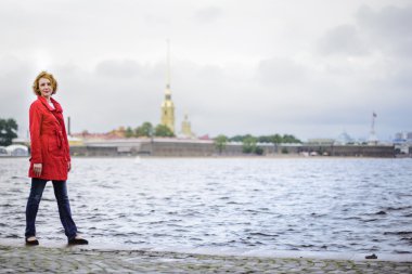 Kırmızı pelerinli genç bir kadının portresi.