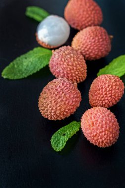 Siyah arka planda taze organik liçi meyvesi..